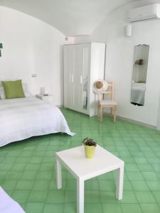 een slaapkamer met een wit bed en een witte tafel bij Casa Vuolo in Atrani