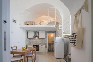 een keuken met een tafel en een witte koelkast bij Casa Vuolo in Atrani