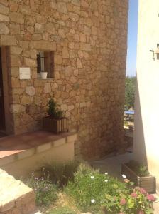 a building with a stone wall with a potted plant at A Stalla in Piana