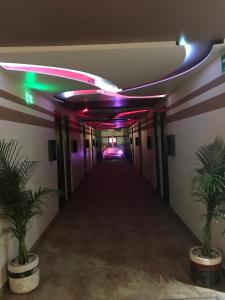 un largo pasillo con luces moradas y verdes en Hotel & Villas 7, en Ciudad de México