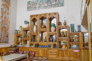 Shaherezada Boutique Hotel في خيوة: غرفة مع خزانة خشبية عليها مزهريات