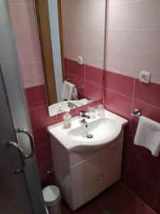 La salle de bains est pourvue d'un lavabo, d'un miroir et de toilettes. dans l'établissement Villa Ruzica, à Trogir