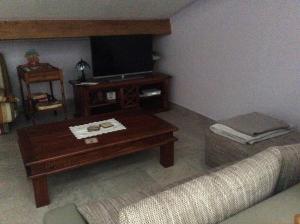 a living room with a coffee table and a tv at Appartement les Ecureuils in La Roque-dʼAnthéron