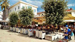 a group of people sitting at tables and chairs at Malik's place in Novalja