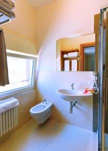uma casa de banho com um lavatório, um WC e um espelho. em Bed & Breakfast Sud em Gallipoli