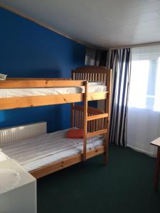 Ce lit se trouve dans un dortoir doté de 2 lits superposés et d'un mur bleu. dans l'établissement Kipperi Turismitalu, à Saulepa