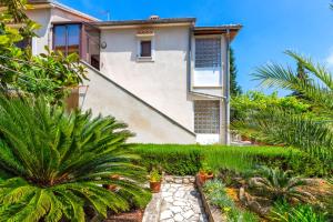 a house with a garden in front of it at Apartmani GORDANA in Mali Lošinj