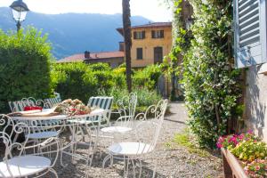 una mesa y sillas en un jardín con vistas en Villa Ruscone, en Lasnigo