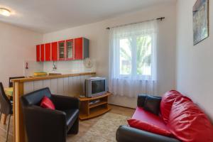 a living room with a couch and a tv at Apartmani GORDANA in Mali Lošinj