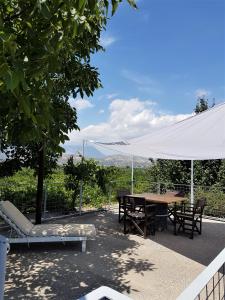 een picknicktafel en stoelen onder een witte tent bij KaliVie Bio Farm & Retreat in Moírai