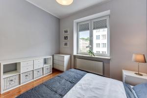 a bedroom with a bed and a window at White 76. Gdynia Śródmieście in Gdynia
