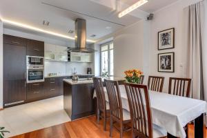 a kitchen with a table and chairs and a kitchen with at White 76. Gdynia Śródmieście in Gdynia