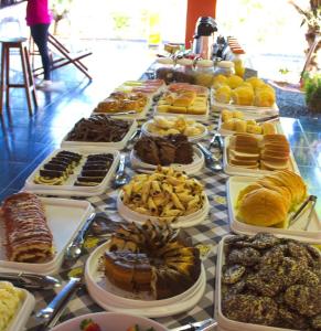 uma mesa cheia de diferentes tipos de pastelarias e sobremesas em Pousada Sol Nascente em Olímpia