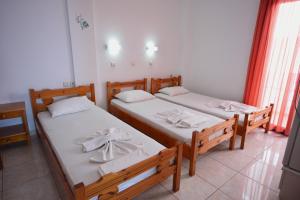 two beds in a room with two lamps on each side at Paralia guest house in Agia Roumeli