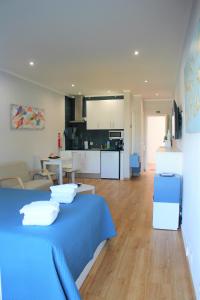 a living room with a blue bed and a kitchen at Vilamoura Dolphin Studio in Vilamoura