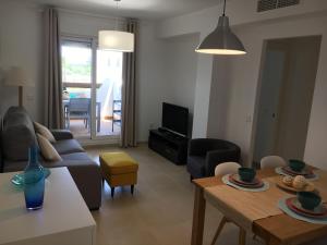 una sala de estar con un sofá y una mesa en Laduana LaCarmen & LaPepa, en Rota