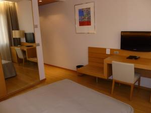 a living room with a desk and a television at Hotel Internazionale in Cervignano del Friuli