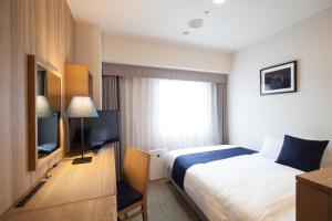 a hotel room with a bed and a television at Hotel St Palace Kurayoshi in Kurayoshi