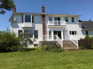 a large white house with a porch and stairs at Seaview White House in Stratford