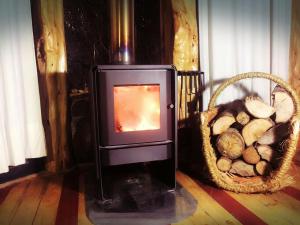 a wood burning stove with a basket of logs at Reserva los Bollenes in Constitución