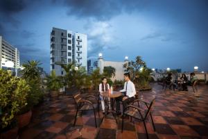 a man and woman sitting at a table on a rooftop at Relax Hotel in Phnom Penh