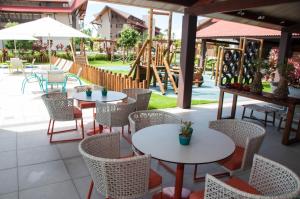 a patio with tables and chairs and a playground at Apto Oka Beach Residence in Porto De Galinhas