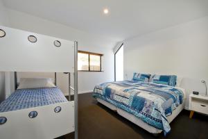 1 Schlafzimmer mit 2 Betten und einem Spiegel in der Unterkunft Margaret River Bungalow-1-street - stylish stay in Margaret River Town