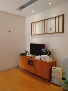 石碇區的住宿－三才靈芝民宿，客厅配有木柜上的电视