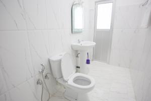 Baño blanco con aseo y lavamanos en Freedom Apartment 1, en Galle