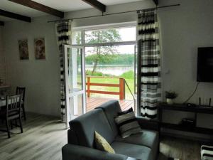 a living room with a couch and a sliding glass door at Port przy Zeglarskiej in Ruciane-Nida