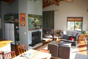 a living room with a couch and a fireplace at Piha Beachstay Accommodation in Piha