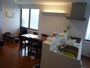 a kitchen with a sink and a table with chairs at MihaMac in Chatan