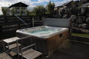 a jacuzzi tub with a chair and a bench at Gasthof Hirschen in Sibratsgfäll