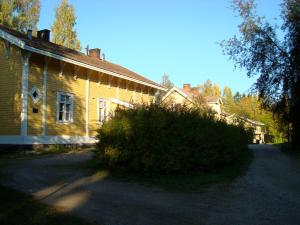 an old house with a large bush in front of it at Gran Hotellihuoneistot 2 in Suolahti