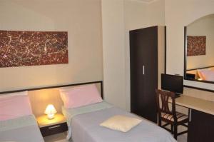 a bedroom with two beds and a desk with a computer at Bed & Breakfast Oasi in Pescara +29 photos