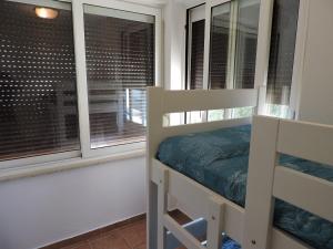 a bedroom with a bunk bed and two windows at Apartment Areta in Ravni