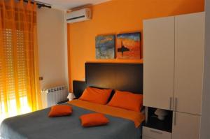 a bedroom with orange walls and a bed with orange pillows at Bed & Breakfast Oasi in Pescara