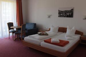 a hotel room with a bed and a chair and a table at Gasthof Hirschen in Sibratsgfäll