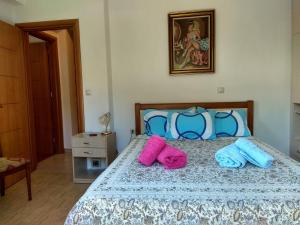 a bedroom with a bed with two towels on it at Flamiatos Garden Cottages in Pouláta