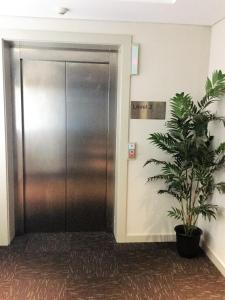 a door is open to a small room with a large mirror at Baileys Serviced Apartments in Perth