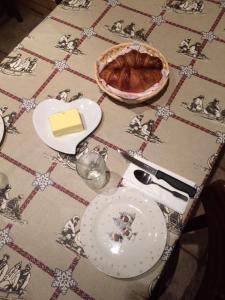 a table with a plate of cheese and a pie at La Grange De L'Errance in Giron