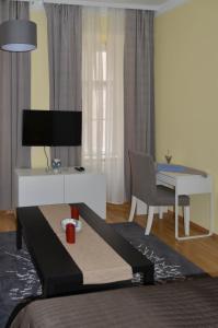 ウィーンにあるAbleidinger Apartmentsのリビングルーム(ベッド1台、テーブル、デスク付)