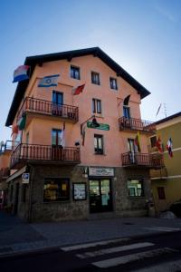 a large building with flags on the side of it at B&B Edelweiss in Castione della Presolana