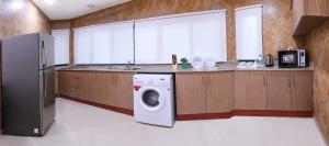a kitchen with a washing machine and a refrigerator at Montana Tower in Manama