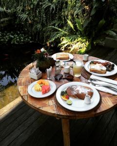 a wooden table with plates of food on it at Sri Ratih Cottages, CHSE Certified in Ubud