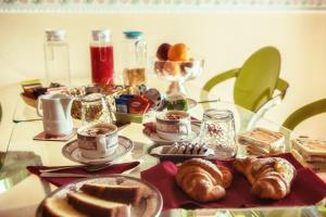 a table topped with plates of pastries and cups of coffee at B&B Cribò in San Giuliano Terme