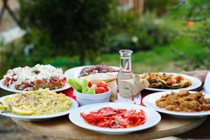 a table with plates of food and a bottle of wine at Petroto Villas in Kiotari