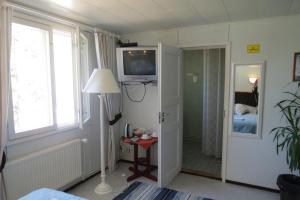 a bedroom with a bed and a television on the wall at Hotel Laatokan Portti in Parikkala