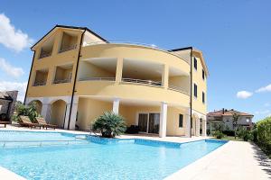 a building with a swimming pool in front of it at B&B Villa Oasa 3 in Rovinjsko Selo