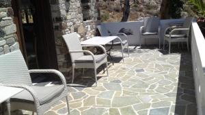 a patio with chairs and tables on a patio at TheArtemis Perissa in Perissa